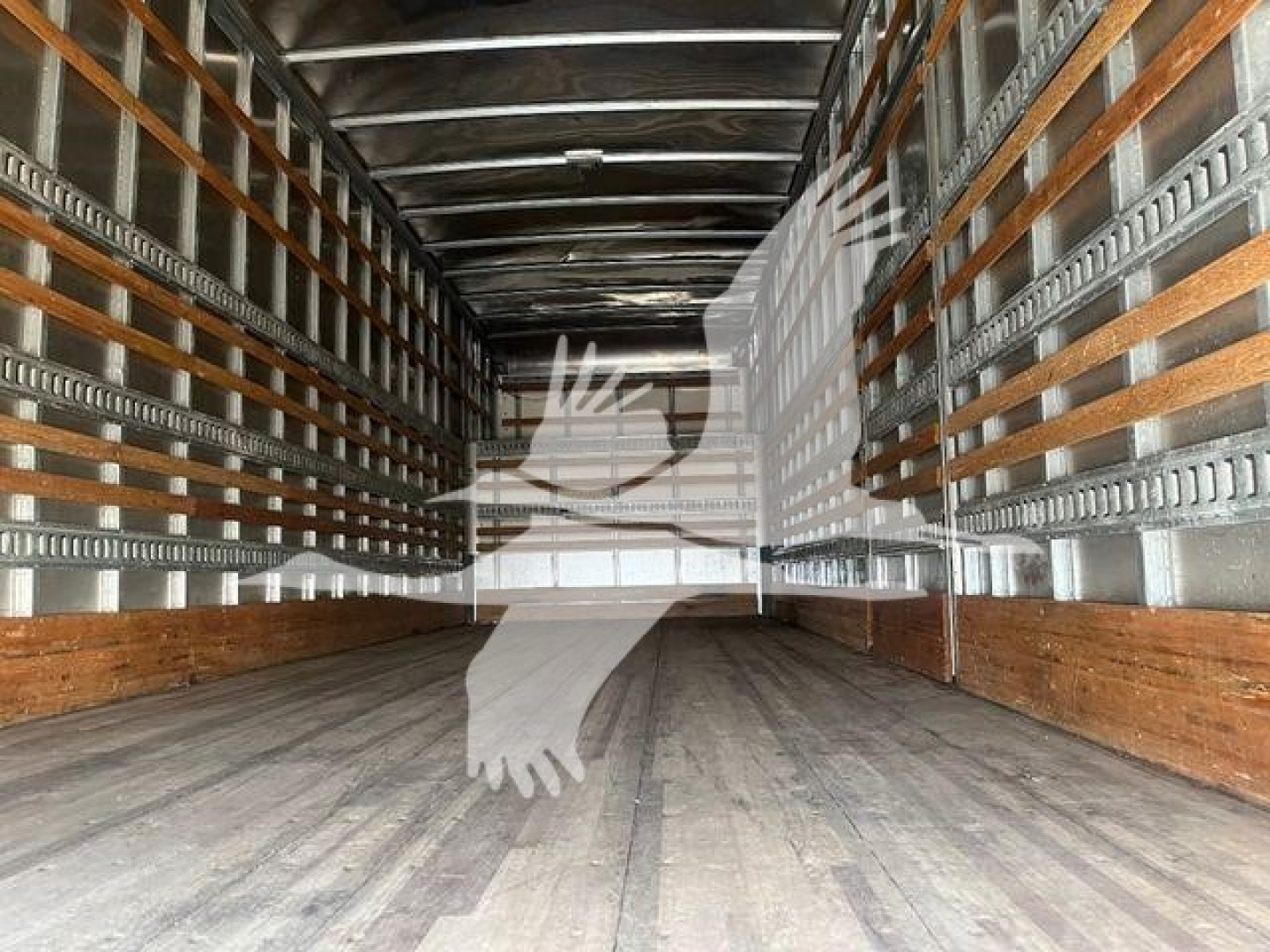 Interior of Freightliner M2 106 trailer or cargo area with wooden side rails and metal channels, empty cargo floor.