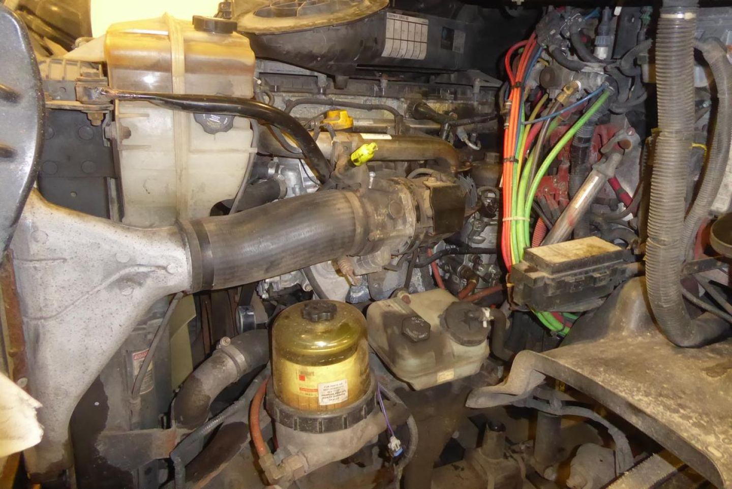 Freightliner Cascadia 113 engine bay showing intake hose and wiring harnesses