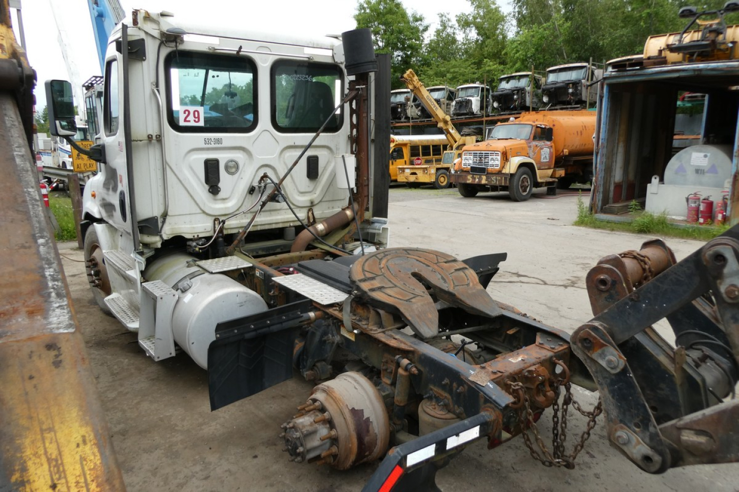 Freightliner Cascadia 113 truck cab and chassis showing front view with exposed drivetrain and rusted components.