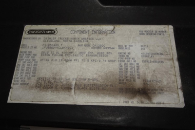 Freightliner component information plate with VIN, engine details, transmission info, and color codes on a white label.
