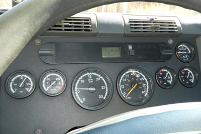 Dashboard of a Freightliner Cascadia 125 showing multiple round gauges, a center digital display, and a right-side gauge cluster.