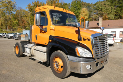 Cab of a 2012 Freightliner Cascadia 125 daycab truck showing orange cab with black lower panels and side mirrors; front grille and headlights visible.