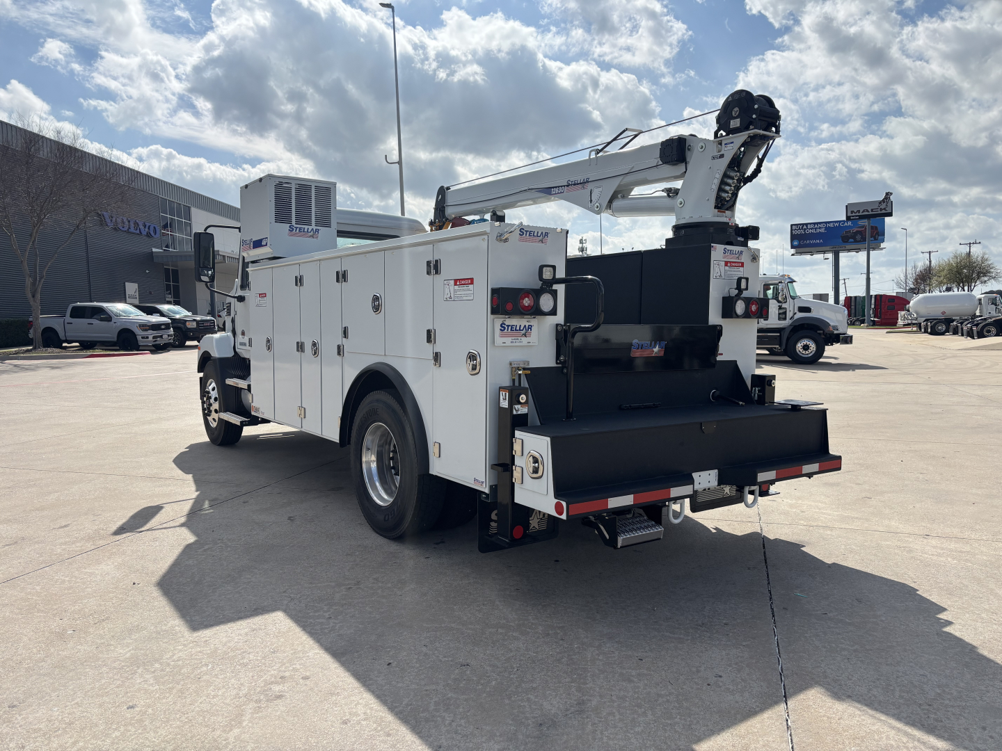 White service/utility truck with an mounted crane at rear, multiple compartments along the sides, viewing from the left-rear. Visible text includes 'Smart' on some panels and utilities, with a crane arm folded over the bed.