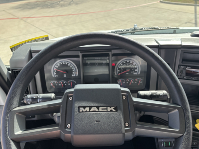 Mack MD7 truck cockpit showing steering wheel with MACK branding and instrument cluster.