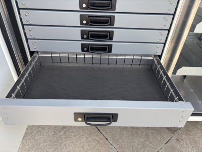 Drawer open showing multiple grey tool drawers stacked in a cabinet with a pull-out lower tray.