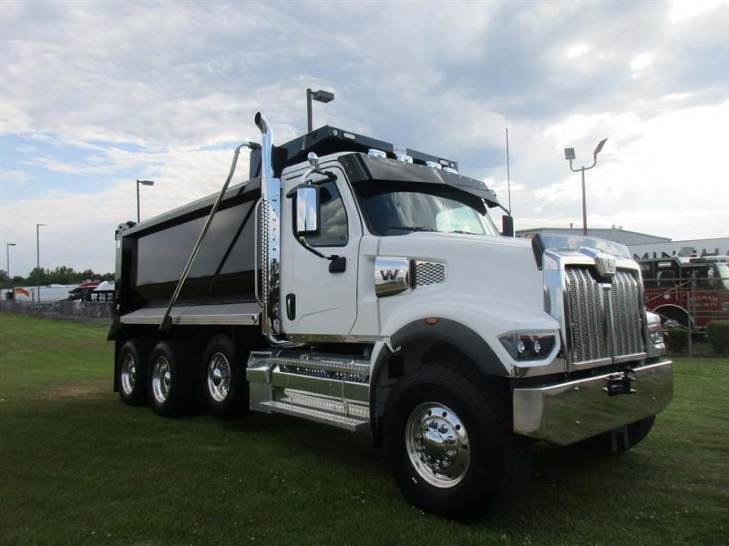 Dump truck in service bay showing a white Western Star 49X dumped bed and chrome accents, side view with dual rear axles.