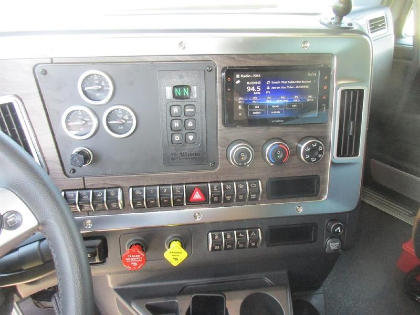 Cab interior of a Western Star 49X dump truck showing instrument cluster, navigation/display screen, gauges, ignition switches, and control buttons.