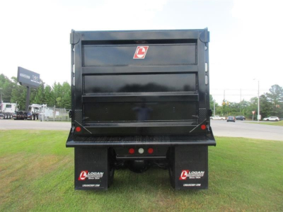 Dump truck bed rear showing Logan mud flaps and rear lights.