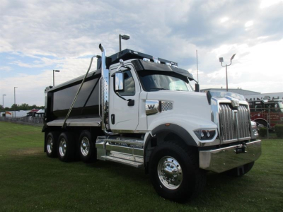 Dump truck in service bay showing a white Western Star 49X dumped bed and chrome accents, side view with dual rear axles.