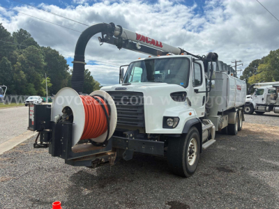 Truck-mounted vacuum trailer with large coiled hose reel andVacall vacuum arm, front grille, and cleaning unit visible.