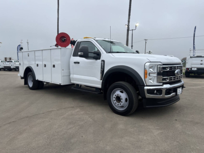 Service/utility truck showing white Ford F-550 with utility bed and mounted reel, side view, stock number 7731.