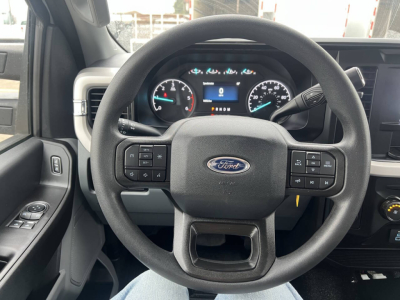 Ford F-550 steering wheel and dashboard with instrument cluster visible; Ford logo on steering wheel; controls on both sides; partial center console.