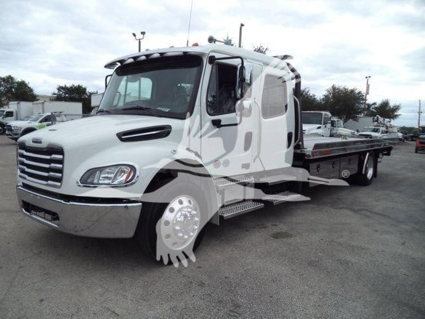 Freightliner M2 106 rollback truck in white with extended cab and flatbed, side step, chrome bumper, and dual rear wheels.