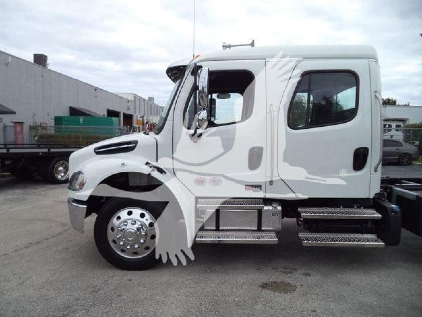 Freightliner M2 106 cab in side view showing front wheel, door, and steps with chrome accents.