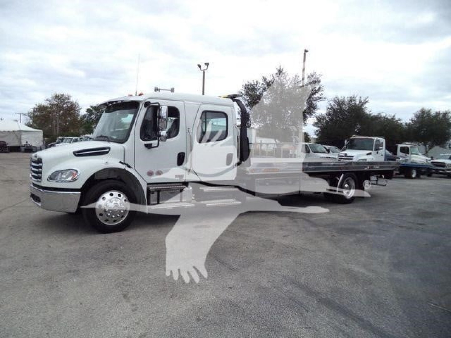 Truck cab and rollback bed showing Freightliner M2 106 in-service with chrome wheels and extended cab.