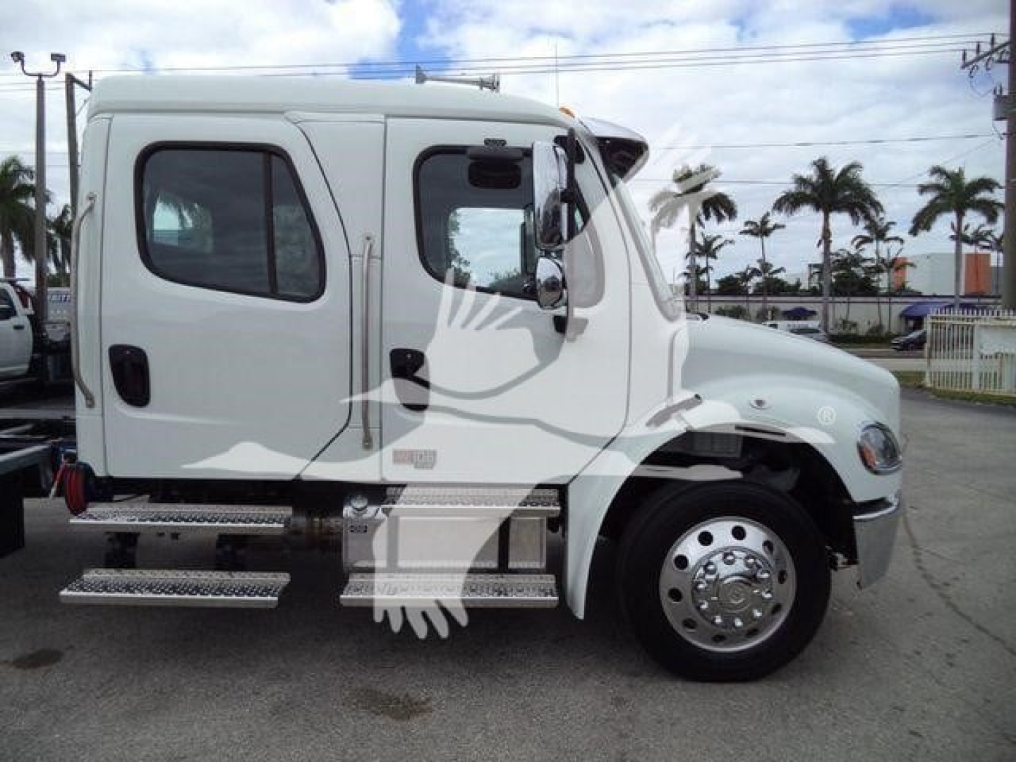 Freightliner M2 106 rollback truck side view showing cab with step boards and large front wheel.
