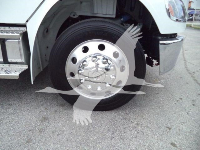 Truck wheel with polished steel hub and black tire, front fender and chrome bumper visible.