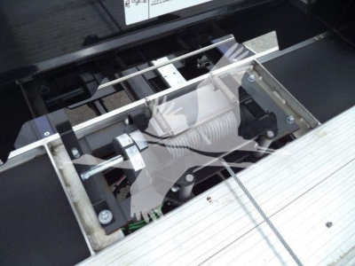 Winch/haulback system visible in Freightliner M2 106 rollback bed showing mechanical winch and mounting frame.