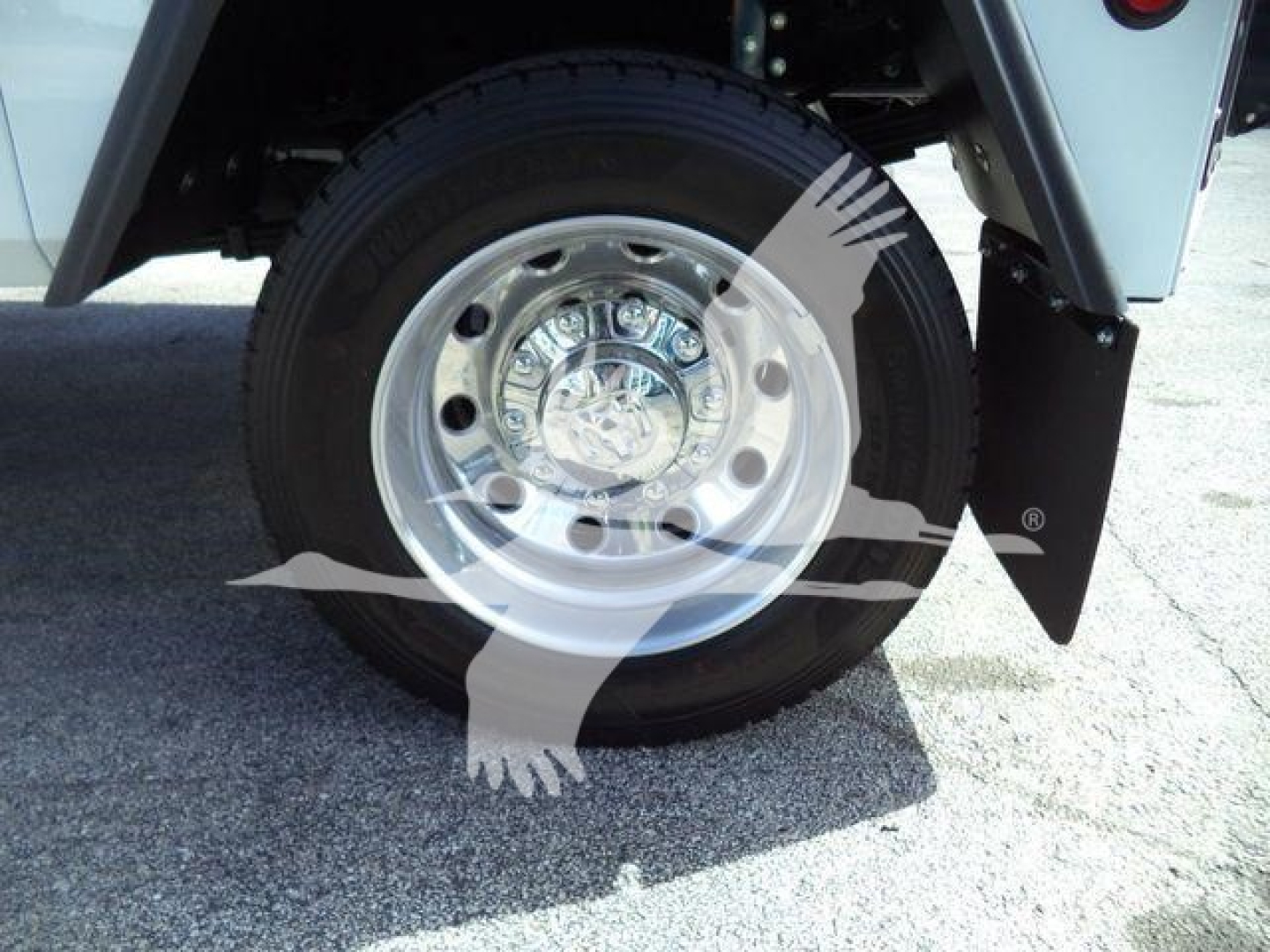 Ram 4500 wheel and tire close-up with chrome hubcap and wheel well; part of a winch-equipped truck likely in a dealership lot.