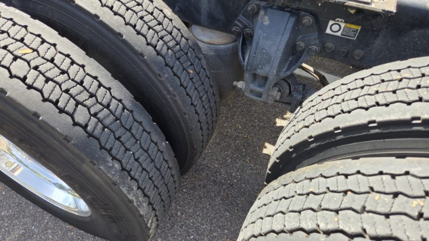 Kenworth truck tires and undercarriage showing dual rear axle configuration and suspension components.
