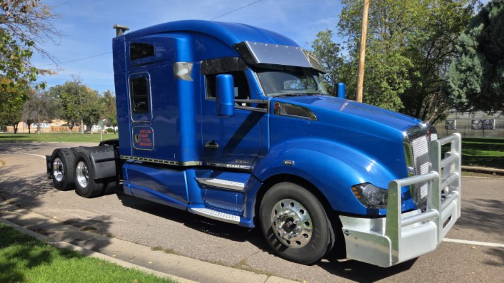 Kenworth T680 sleeper cab truck in blue, front grille guard, chrome wheels, dual rear axles, side steps, stock number 0633951