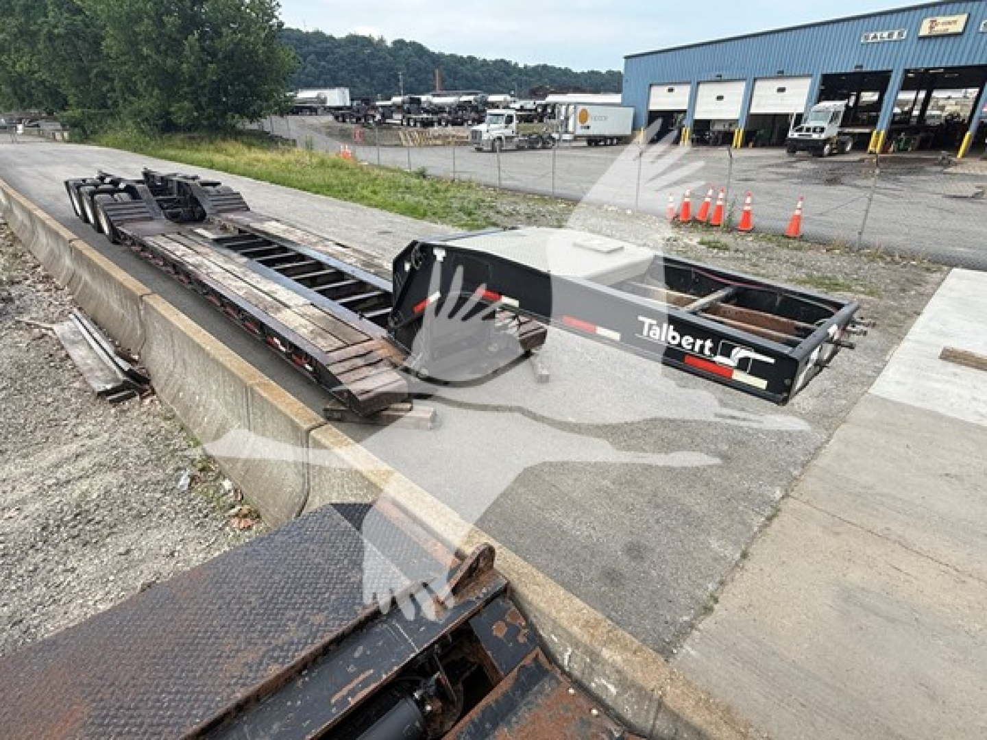 Talbert 55CC lowboy trailer in a yard showing the deck and frame with branding visible.