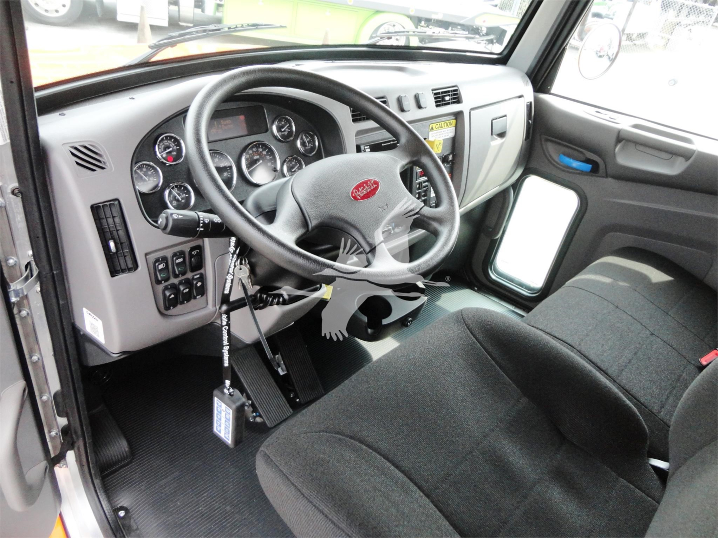 Truck cab interior of a 2022 Peterbilt 337 RB showing steering wheel, instrument cluster, and driver seat