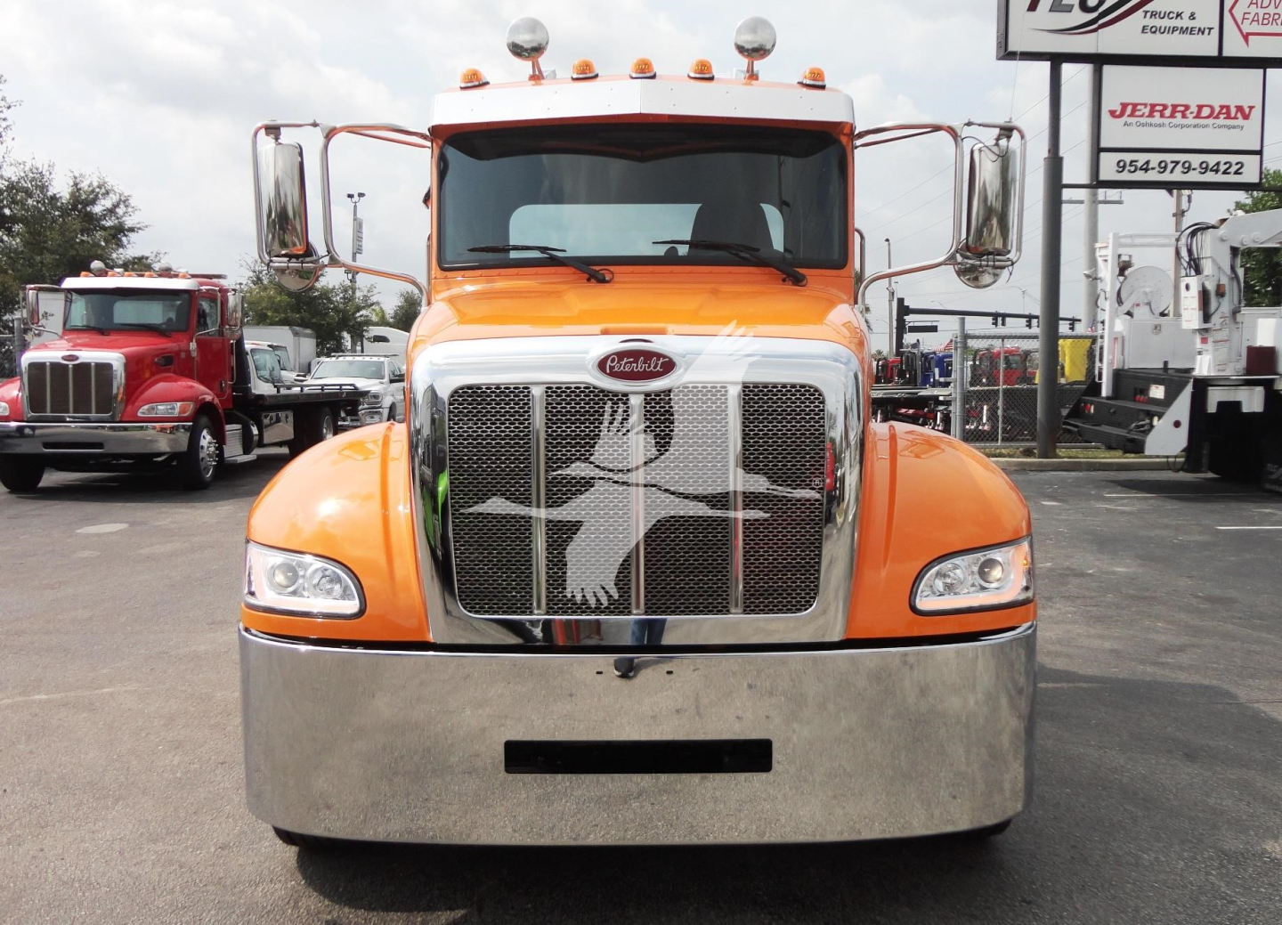 Peterbilt 337 front view with orange cab and chrome grille, large bumper, emblem on grille.