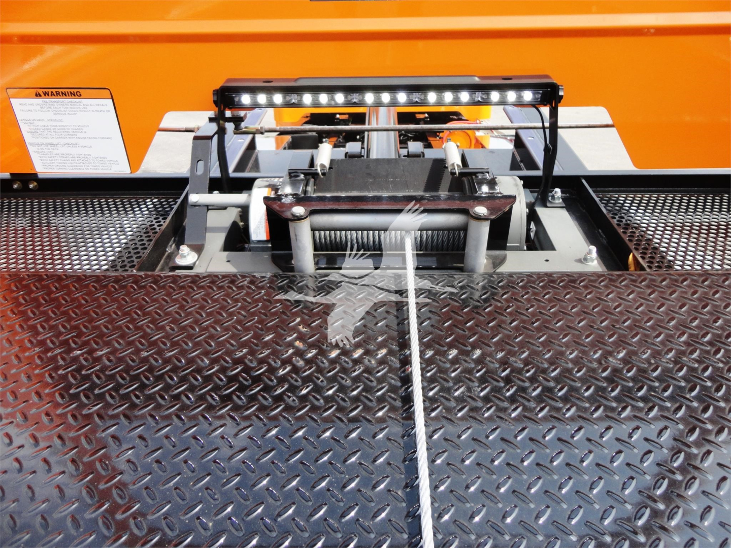 Peterbilt 337 rollback hitch mechanism with diamond plate truck bed and LED light bar visible.