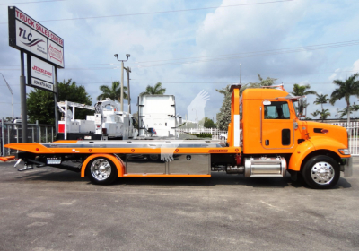 Peterbilt 337 rollback tow truck in orange with flatbed, side view showing cab and tow equipment