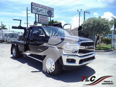 Ram 4500 SLT tow truck with large chrome grille and oversized front wheels, winch setup visible in bed, black and chrome color scheme, dealership lot background.