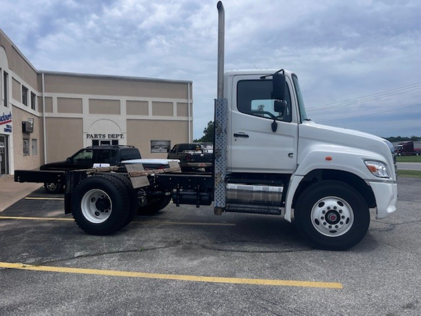 2026 Hino XL7 cab and chassis truck side view with tall exhaust stack, white cab, and chassis chassis frame, no visible side text.
