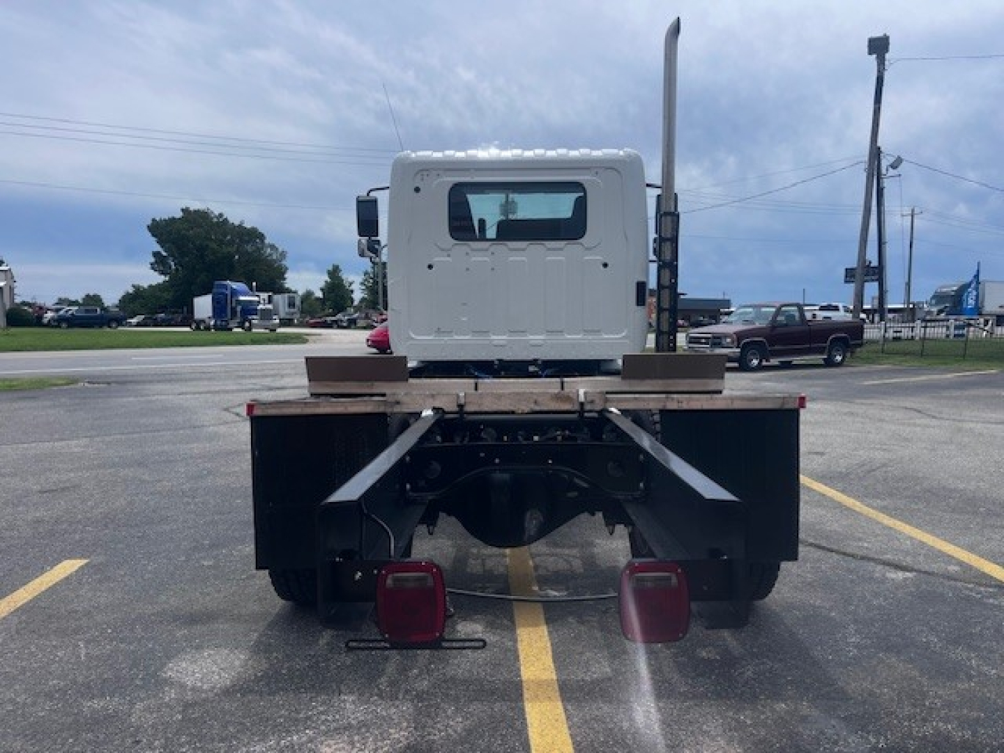 Rear view of a new 2026 Hino XL7 cab and chassis showing rear bumper, taillights, and chassis frame.
