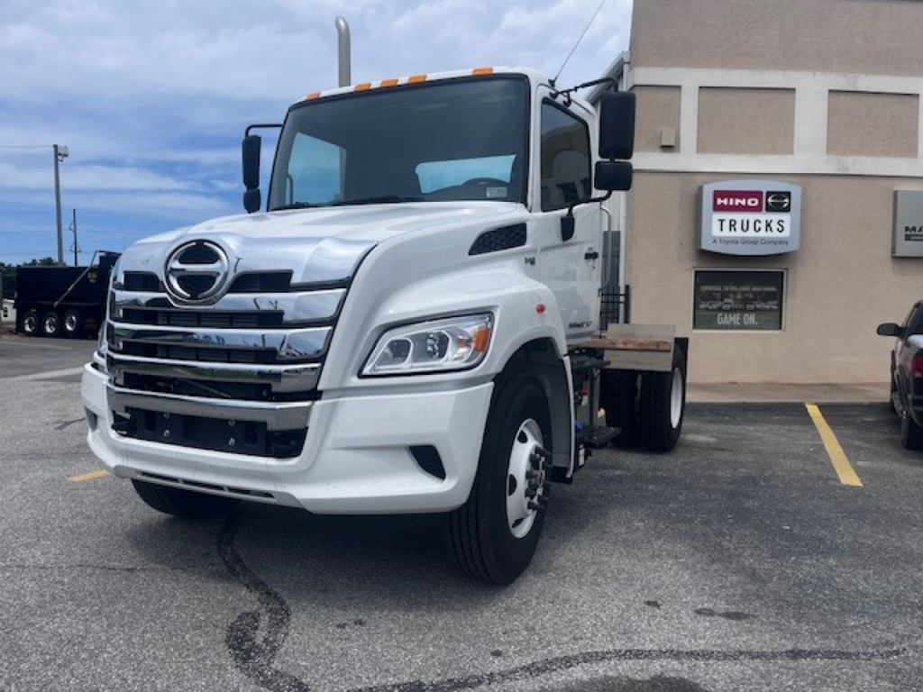 Hino XL7 cab and chassis truck front-left view showing white body and chrome grille with Hino emblem.