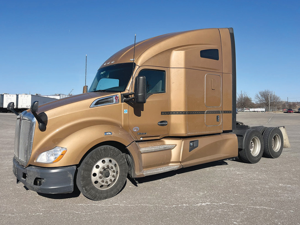 Kenworth T680 cab with tan paint in sleeper configuration, side view showing front wheel and rear dual axle.