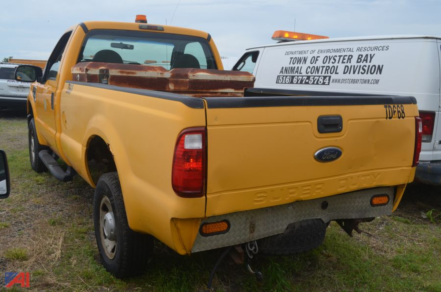 Ford F-250 Super Duty dump truck from rear-left perspective showing bed cap and tailgate with Ford emblem.