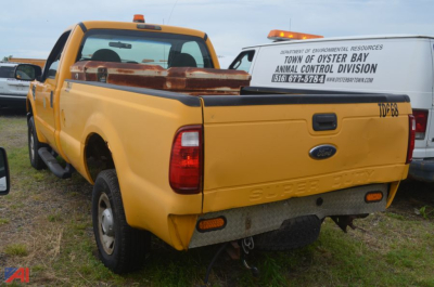 Ford F-250 Super Duty dump truck from rear-left perspective showing bed cap and tailgate with Ford emblem.