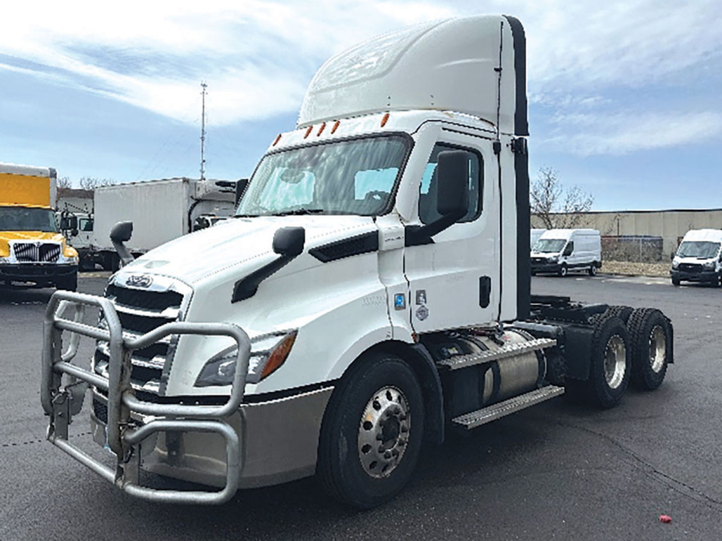 Truck cab front quarter view showing Freightliner Cascadia115? badge not visible; grille guard and aerodynamic mirrors; white exterior