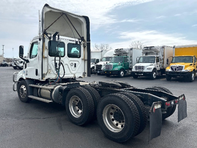 Freightliner Cascadia116 tractor with fifth wheel and dual rear axles, cab interior visible, daycab configuration.