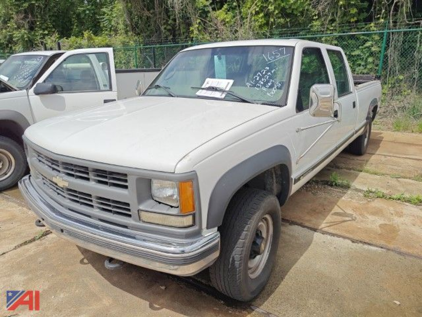 Chevrolet K3500 crew cab pickup with liftgate, front three-quarter view, beige/gray body, Chevrolet emblem on grille, utility truck style.