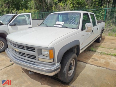 Chevrolet K3500 crew cab pickup with liftgate, front three-quarter view, beige/gray body, Chevrolet emblem on grille, utility truck style.