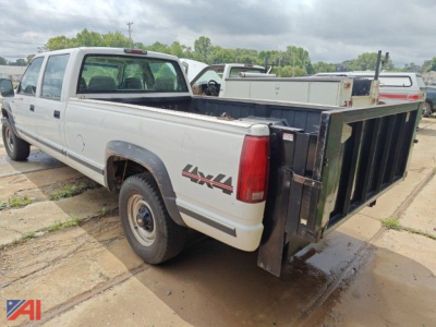 Chevrolet K3500 crew cab pickup truck with liftgate, in-service four-wheel drive, white with black dump bed at rear.
