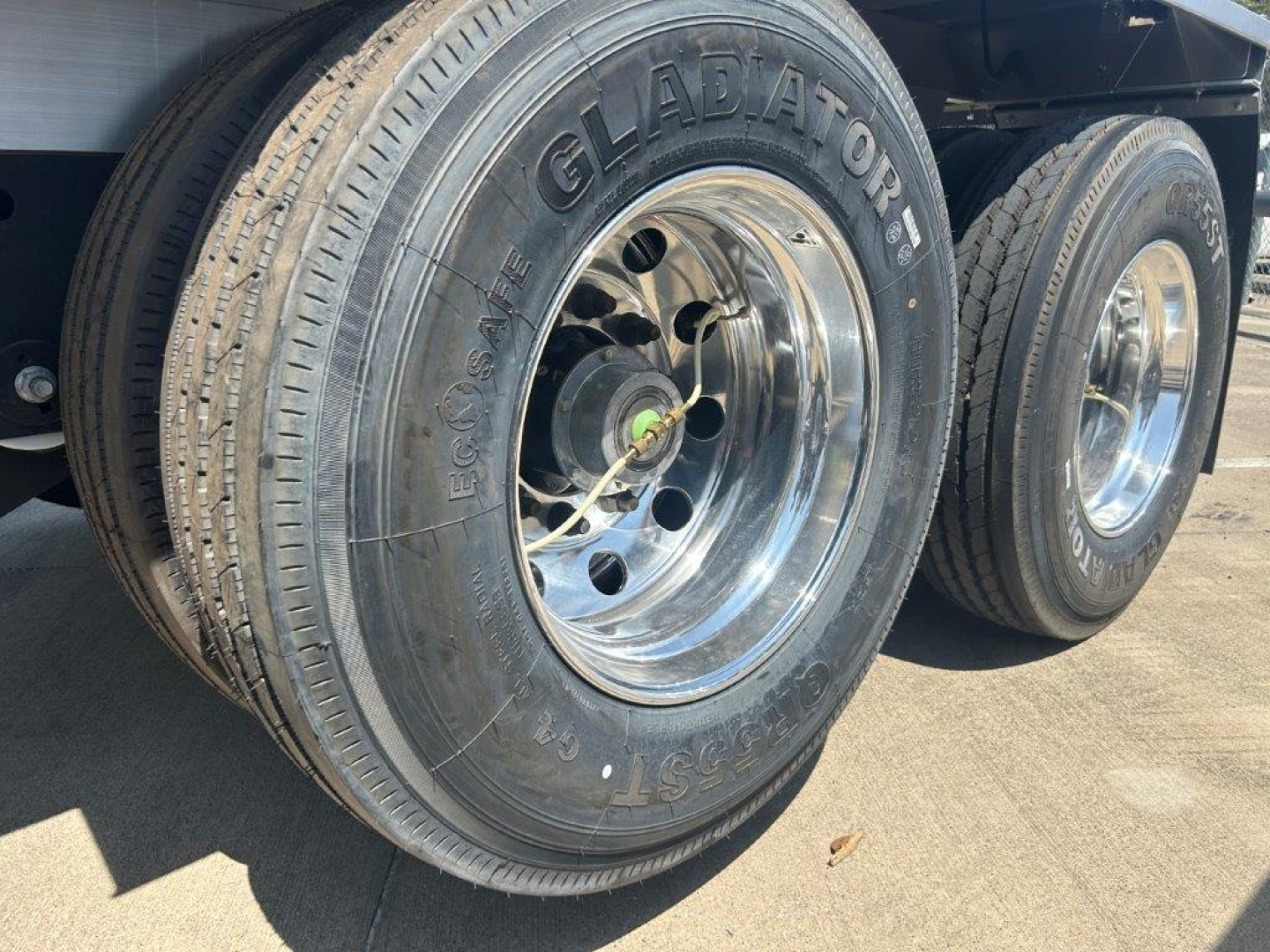 Trailer wheel and tire close-up showing Glabator tire brand with polished chrome hub, dual rear axle, and RV trailer wheel components.