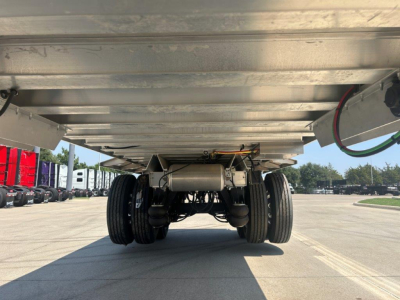 Underbody view of a trailer with dual rear axles and suspension; no legible text visible on components in this view.