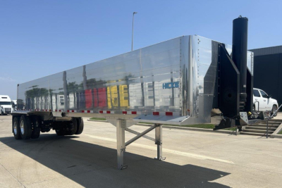 Trailer showing A-frame channel steel legs, polished aluminum dump trailer with HICKS logo, black hitch assembly, and dual rear axles; no visible text other than small HICKS logo.