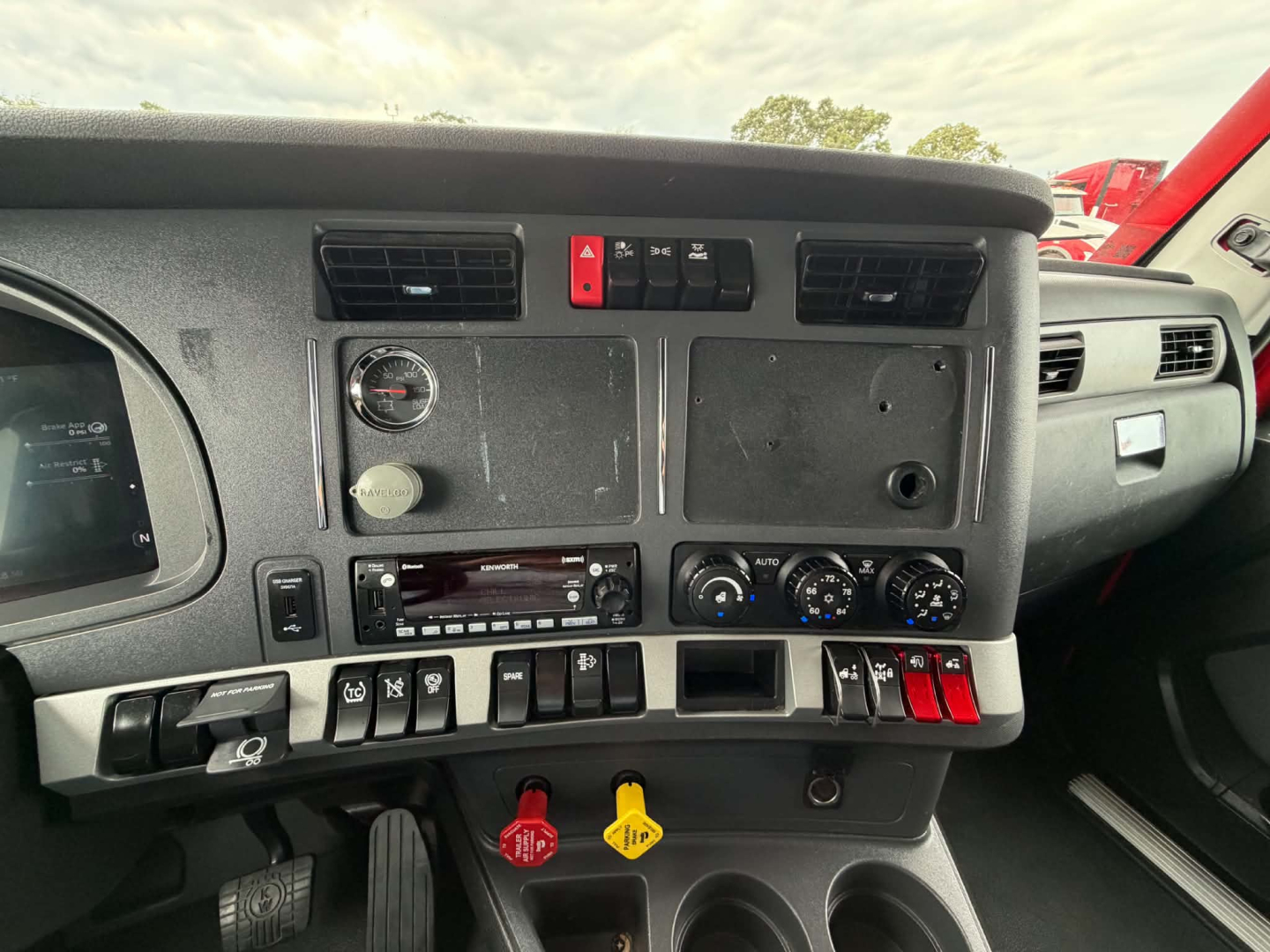 Kenworth T680 truck dash panel with vents, climate controls, switches, and gauge cluster visible.