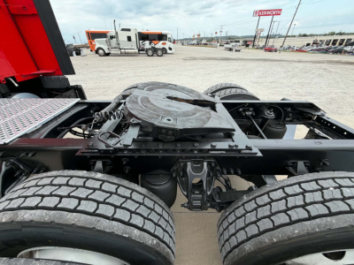Kenworth T680 chassis view showing rear dual axle suspension and fifth wheel mounting plate with tires visible.