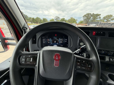 Kenworth T680 cockpit steering wheel and dash view showing steering wheel logo and digital gauges.