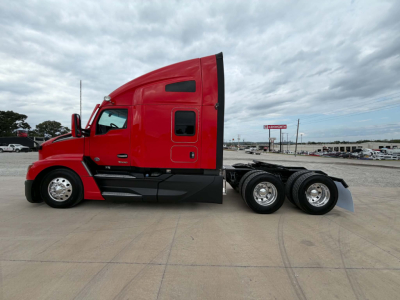 Kenworth T680 side view shows red cab and sleeper with triple rear axles, fuel tanks and steps visible.