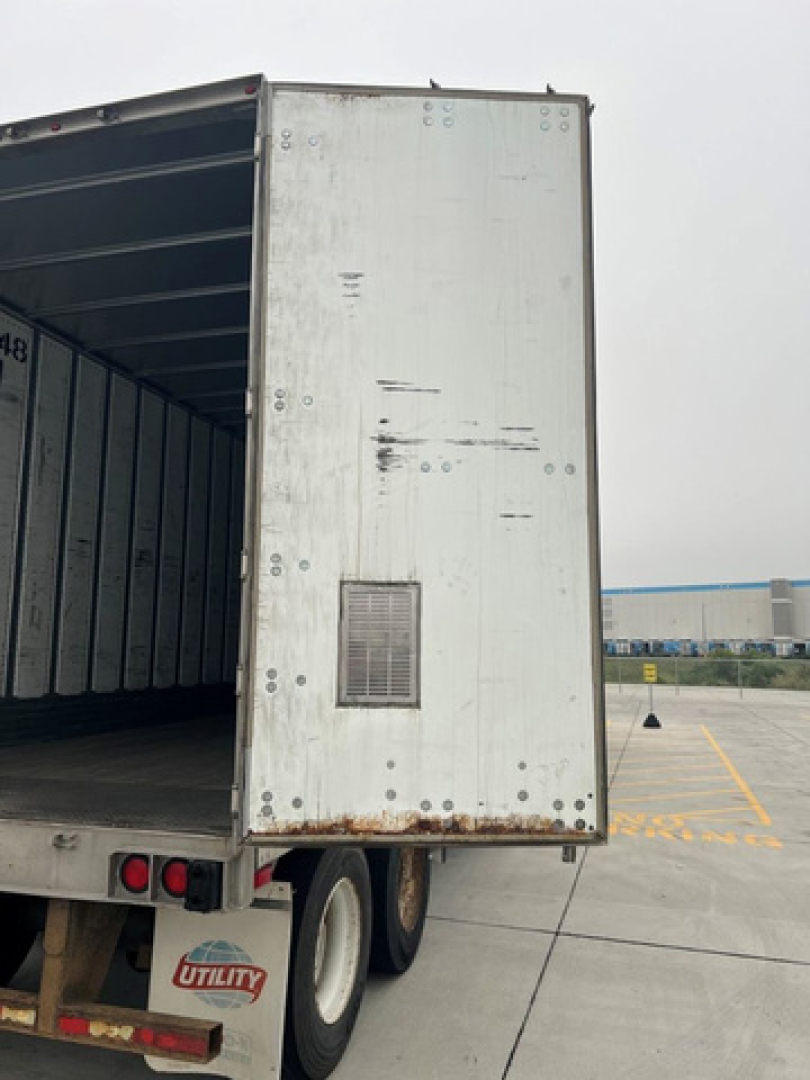 Trailer rear of a 2014 Utility Van showing open cargo area and aluminum exterior with vent on door.